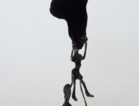 Escultura de metal pintando en negro, una figura humana sostiene a otra figura que, a su vez, sostiene el mapa del continente africano.